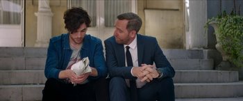 Movie still from “Madame” (2017), directed by Amanda Sthers – A man in a suit sitting next to another man in a suit; Medium shot, Over the shoulder angle