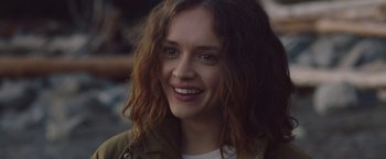 Movie still from “Little Fish” (2020), directed by Chad Hartigan – A person smiling with long brown hair; Close Up shot, Over the shoulder angle