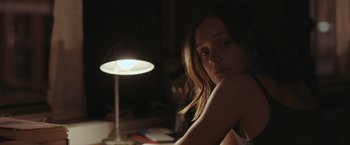 Movie still from “Little Fish” (2020), directed by Chad Hartigan – A woman sitting in front of a table with a lamp; Close Up shot, Over the shoulder angle
