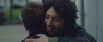 Movie still from “Little Fish” (2020), directed by Chad Hartigan – A man is hugging another man and smiling for the camera; Close Up shot, Over the shoulder angle