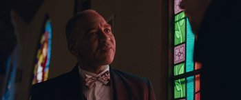 Movie still from “Little Fish” (2020), directed by Chad Hartigan – A man in a suit and bow tie looking up; Close Up shot, Low angle