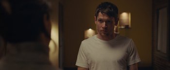 Movie still from “Little Fish” (2020), directed by Chad Hartigan – A man in a white shirt is standing in a room; Close Up shot, Over the shoulder angle