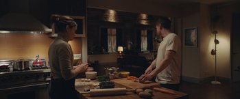 Movie still from “Little Fish” (2020), directed by Chad Hartigan – A man and a woman preparing food on a wooden table; Medium shot, High angle
