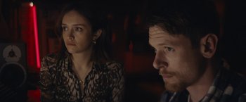 Movie still from “Little Fish” (2020), directed by Chad Hartigan – A man and a woman sitting next to each other in a dark room; Close Up shot, Over the shoulder angle