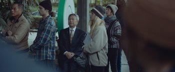 Movie still from “Little Fish” (2020), directed by Chad Hartigan – A group of people standing next to each other on the street; Medium shot, Over the shoulder angle