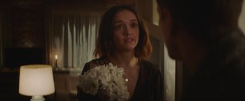 Movie still from “Little Fish” (2020), directed by Chad Hartigan – A woman holding a bunch of flowers in a room; Close Up shot, Over the shoulder angle