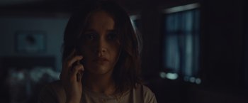 Movie still from “Little Fish” (2020), directed by Chad Hartigan – A woman is talking on a cell phone in a dark room; Close Up shot, Low angle