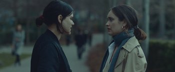 Movie still from “Little Fish” (2020), directed by Chad Hartigan – Two women standing next to each other on the sidewalk; Close Up shot, Over the shoulder angle