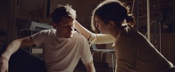 Movie still from “Little Fish” (2020), directed by Chad Hartigan – A man and a woman are sitting in a room together; Medium shot, High angle