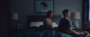 Movie still from “Little Fish” (2020), directed by Chad Hartigan – A woman sitting on a bed next to a man; Medium shot, Over the shoulder angle
