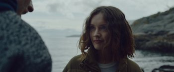 Movie still from “Little Fish” (2020), directed by Chad Hartigan – A woman with long brown hair standing next to a body of water; Close Up shot, Over the shoulder angle