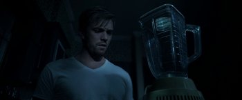 Movie still from “Malignant” (2021), directed by James Wan – A man standing next to a blender in a dark room; Close Up shot, Over the shoulder angle