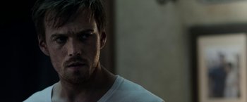 Movie still from “Malignant” (2021), directed by James Wan – A person wearing a white t - shirt; Close Up shot, Over the shoulder angle