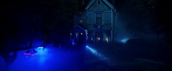Movie still from “Malignant” (2021), directed by James Wan – People are walking in front of a house at night; Extreme Wide shot, Low angle