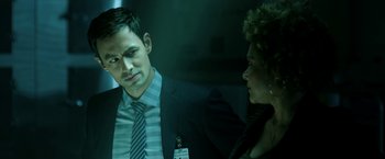 Movie still from “Malignant” (2021), directed by James Wan – A man and a woman are talking in a dark room; Close Up shot, Over the shoulder angle