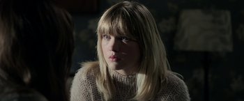Movie still from “Malignant” (2021), directed by James Wan – A woman with blonde hair wearing a pink sweater; Close Up shot, Over the shoulder angle