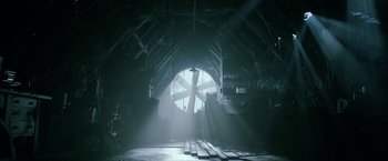 Movie still from “Malignant” (2021), directed by James Wan – A large circular window in the middle of a room; Extreme Wide shot, Low angle