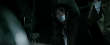 Movie still from “Malignant” (2021), directed by James Wan – A woman with duct tape around her mouth; Close Up shot, Over the shoulder angle