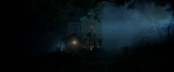 Movie still from “Malignant” (2021), directed by James Wan – A house in the middle of the night with fog; Extreme Wide shot, Low angle