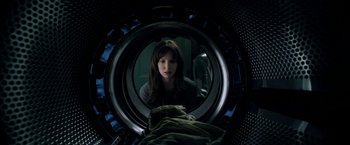 A woman is looking into a washing machine