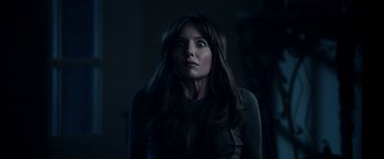 Movie still from “Malignant” (2021), directed by James Wan – A woman with long dark hair stares into the distance; Close Up shot, Low angle