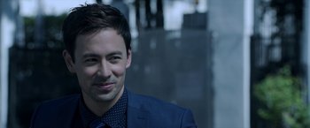 Movie still from “Malignant” (2021), directed by James Wan – A person wearing a suit and tie; Close Up shot, Over the shoulder angle