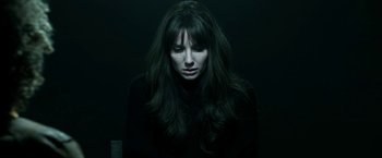 Movie still from “Malignant” (2021), directed by James Wan – A woman with long dark hair is looking at the camera; Close Up shot, High angle