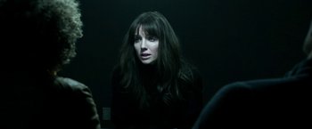 Movie still from “Malignant” (2021), directed by James Wan – A woman sitting in a dark room with long dark hair; Close Up shot, Over the shoulder angle