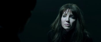 Movie still from “Malignant” (2021), directed by James Wan – A woman with long brown hair is looking at the camera; Close Up shot, Over the shoulder angle