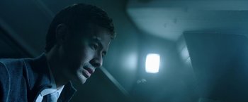 Movie still from “Malignant” (2021), directed by James Wan – A young man looking into a window in a dark room; Close Up shot, Low angle