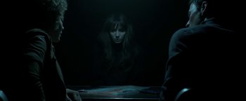 Movie still from “Malignant” (2021), directed by James Wan – A woman sitting in front of a mirror in a dark room; Medium shot, Over the shoulder angle