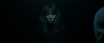 Movie still from “Malignant” (2021), directed by James Wan – A woman with long dark hair and bangs in the dark; Close Up shot, Overhead angle