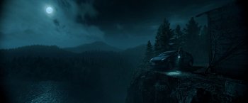 Movie still from “Malignant” (2021), directed by James Wan – A car parked on top of a cliff at night; Extreme Wide shot, High angle