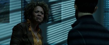 Movie still from “Malignant” (2021), directed by James Wan – A woman with curly hair is looking at a man; Close Up shot, Over the shoulder angle