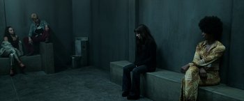 Movie still from “Malignant” (2021), directed by James Wan – A woman sitting on a bench in front of a urinal; Wide shot, High angle
