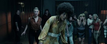 Movie still from “Malignant” (2021), directed by James Wan – A group of people standing in a room; Medium shot, Low angle