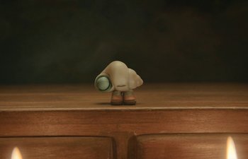 Movie still from “Marcel the Shell with Shoes On” (2021), directed by Dean Fleischer Camp – A small figurine is holding something in its mouth; Extreme Close Up shot, Overhead angle