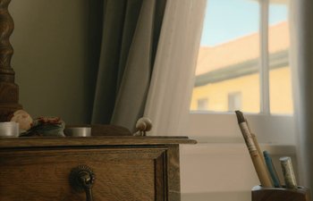 Movie still from “Marcel the Shell with Shoes On” (2021), directed by Dean Fleischer Camp – An old wooden desk with a candle on top of it; Medium shot, Low angle