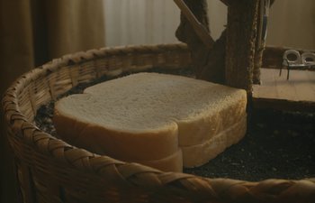 Movie still from “Marcel the Shell with Shoes On” (2021), directed by Dean Fleischer Camp – A piece of white bread in a wicker basket; Extreme Close Up shot, High angle