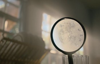 Movie still from “Marcel the Shell with Shoes On” (2021), directed by Dean Fleischer Camp – A magnifying glass sitting on top of a table; Extreme Close Up shot, High angle