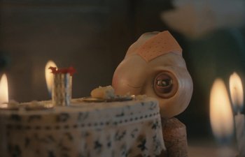 Movie still from “Marcel the Shell with Shoes On” (2021), directed by Dean Fleischer Camp – A cake on a table with a candle; Extreme Close Up shot, High angle