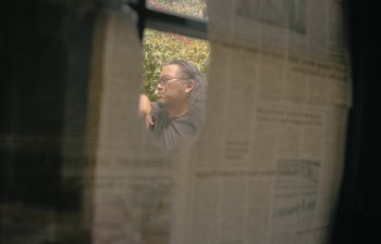 Movie still from “Marcel the Shell with Shoes On” (2021), directed by Dean Fleischer Camp – A man looking out of a window through a window; Medium shot, Low angle
