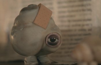 Movie still from “Marcel the Shell with Shoes On” (2021), directed by Dean Fleischer Camp – An eye with bandage sticking out of it's head; Extreme Close Up shot, High angle