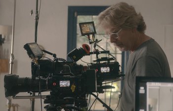 Movie still from “Marcel the Shell with Shoes On” (2021), directed by Dean Fleischer Camp – A man standing in front of a video camera; Close Up shot, Over the shoulder angle