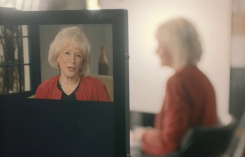 Movie still from “Marcel the Shell with Shoes On” (2021), directed by Dean Fleischer Camp – An older woman in a red jacket sitting in front of a computer screen; Close Up shot, Over the shoulder angle