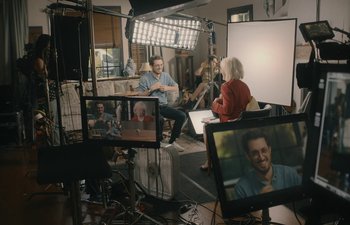 Movie still from “Marcel the Shell with Shoes On” (2021), directed by Dean Fleischer Camp – A group of people sitting in a room with a television set; Wide shot, Over the shoulder angle