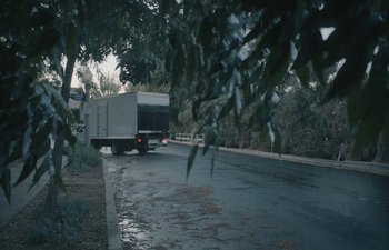 Movie still from “Marcel the Shell with Shoes On” (2021), directed by Dean Fleischer Camp – A truck driving down a street next to trees; Extreme Wide shot, Low angle