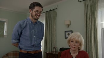 Movie still from “Marcel the Shell with Shoes On” (2021), directed by Dean Fleischer Camp – A man standing next to an older woman in a living room; Medium shot, Over the shoulder angle