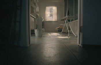 Movie still from “Marcel the Shell with Shoes On” (2021), directed by Dean Fleischer Camp – A room with a window and a ironing board in the middle of the room; Wide shot, High angle