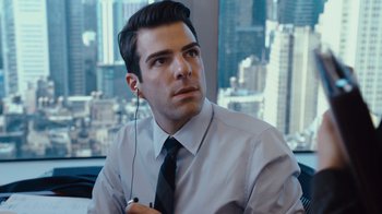 Movie still from “Margin Call” (2011), directed by J.C. Chandor – A man in a shirt and tie holding a pair of headphones; Close Up shot, Over the shoulder angle